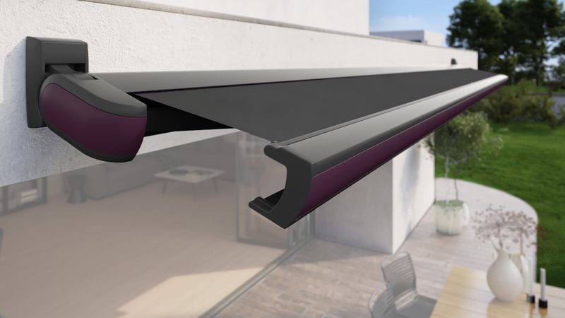 Cassette awning MX-3 with black fabric cover, black frame and purple cover profile fixed to a house wall