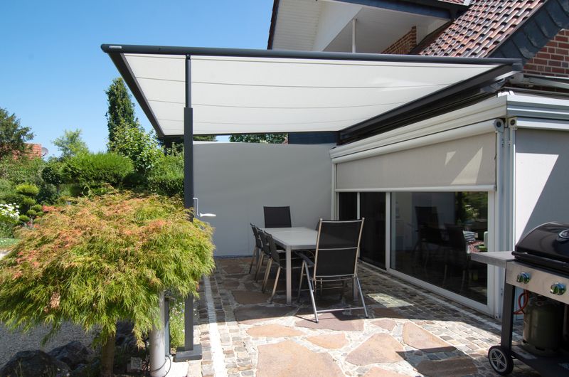 Reference image mx pergola compact 790 with cream-colored fabric cover and anthracite-colored frame over a terrace in Ladbergen