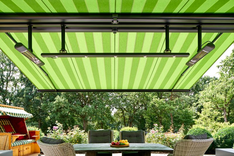 Reference picture: Detail view of cassette awning markilux 5010 (frame anthracite, fabric cover green striped) equipped with infrared heaters and LED-Spotline.