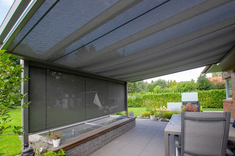 Side view under a patio roof with markilux under-glass awning with transparent fabric cover, frontal is also vertical blind.